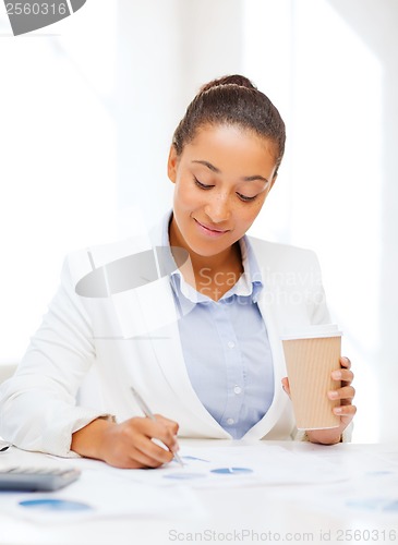 Image of businesswoman with documents and takeaway coffee