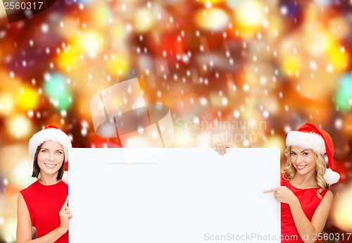 Image of women in santa helper hats with blank white board