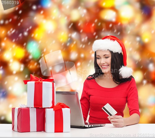 Image of woman with gifts, laptop computer and credit card