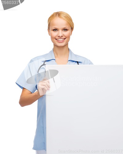 Image of smiling female doctor or nurse with blank board