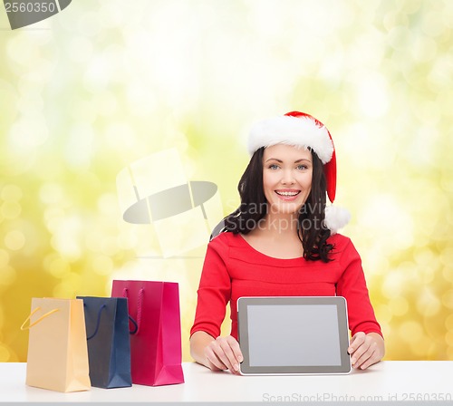 Image of smiling woman in santa helper hat with tablet pc