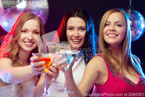 Image of three smiling women with cocktails and disco ball