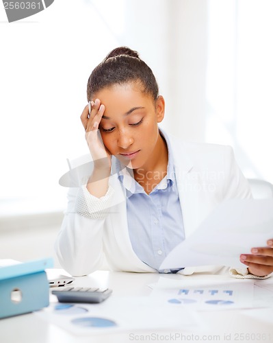 Image of businesswoman working with calculator in office