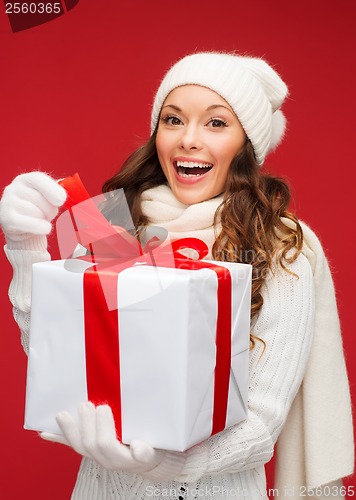 Image of smiling woman in white clothes with gift box