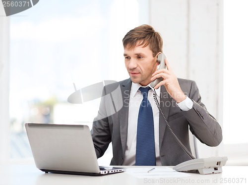 Image of businessman with laptop computer and phone