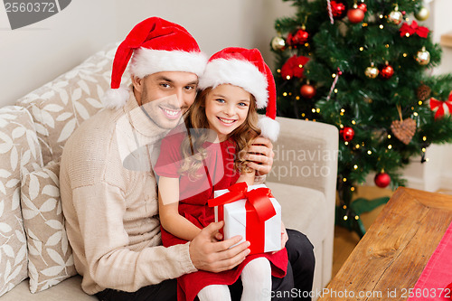 Image of smiling father and daughter holding gift box