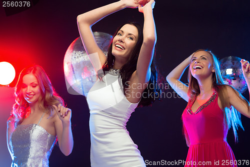 Image of three smiling women dancing in the club