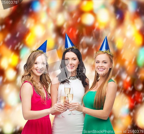 Image of three women wearing hats with champagne glasses