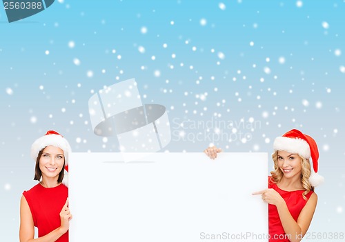 Image of women in santa helper hats with blank white board