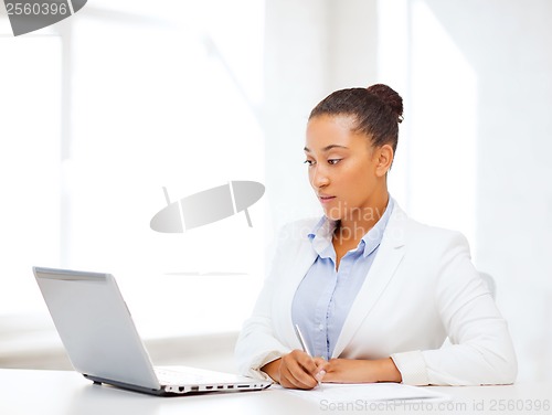 Image of african businesswoman writing something