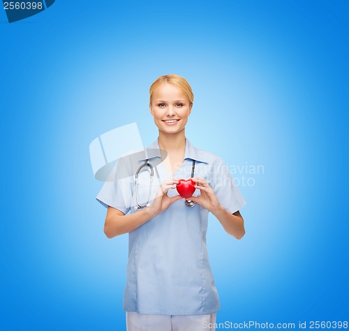 Image of smiling female doctor or nurse with heart