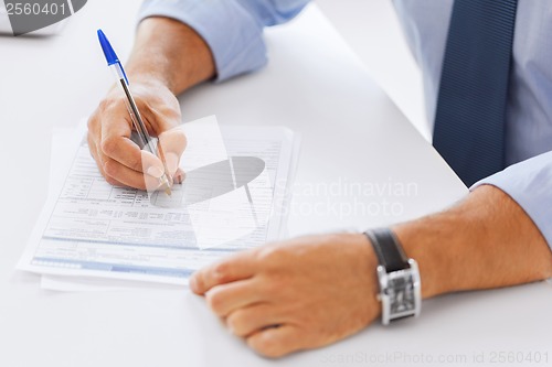 Image of man signing a contract