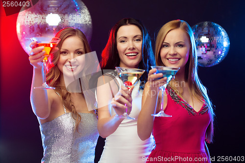 Image of three smiling women with cocktails and disco ball