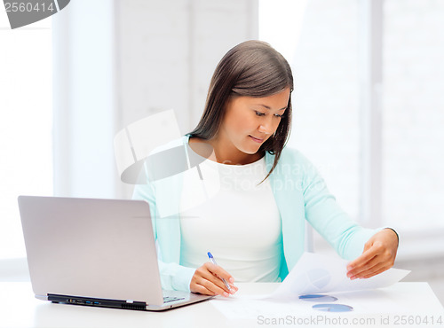 Image of asian businesswoman with laptop and documents