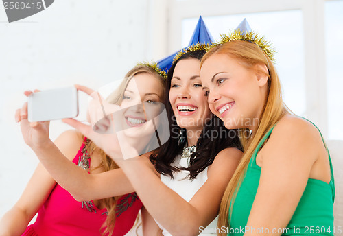 Image of three smiling women in hats having fun with camera