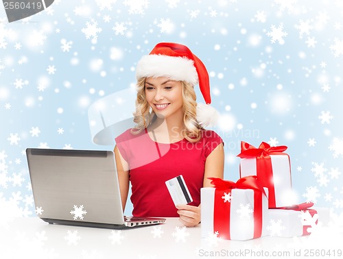 Image of woman with gifts, laptop computer and credit card
