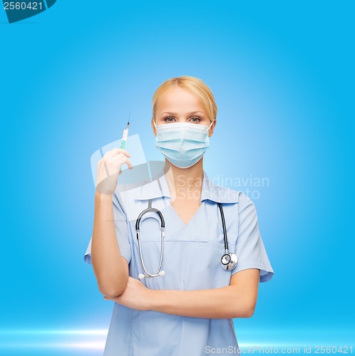 Image of female doctor or nurse in mask holding syringe