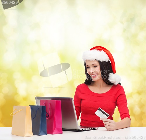 Image of woman with gifts, laptop computer and credit card