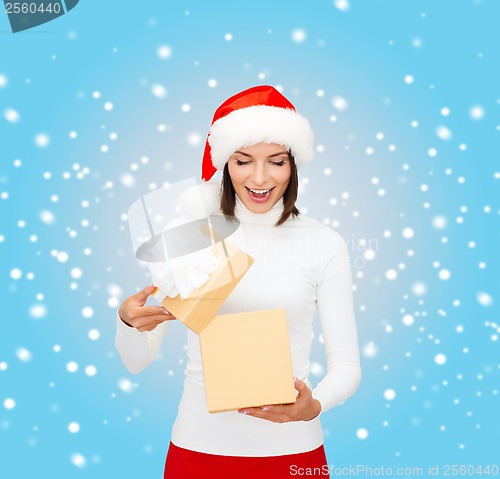 Image of surprised woman in santa helper hat with gift box