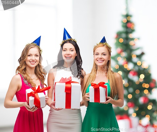 Image of three smiling women in blue hats with gift boxes