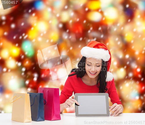 Image of smiling woman in santa helper hat with tablet pc