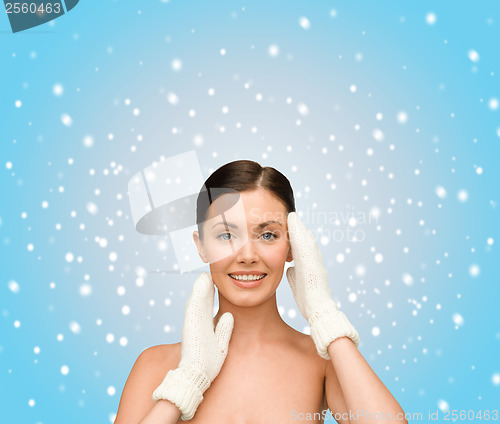 Image of smiling young woman in white mittens