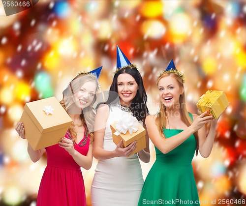 Image of three smiling women in blue hats with gift boxes