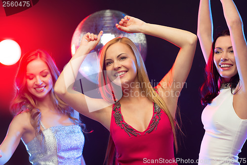 Image of three smiling women dancing in the club