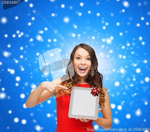 Image of smiling woman in red dress with tablet pc