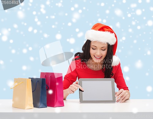 Image of woman in santa helper hat with tablet pc