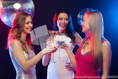 Image of three smiling women with cocktails and disco ball