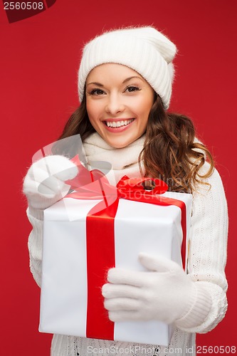 Image of smiling woman in white clothes with gift box