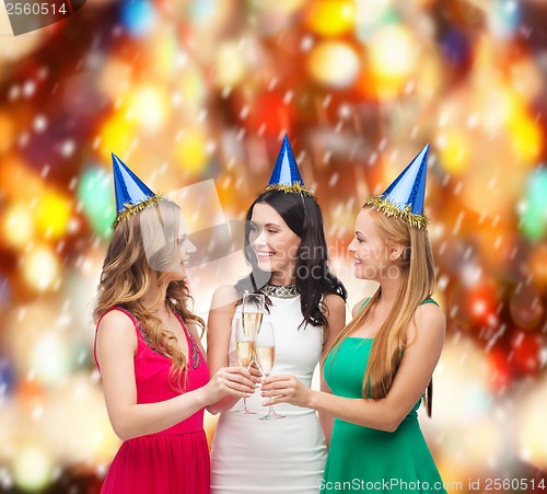 Image of three women wearing hats with champagne glasses