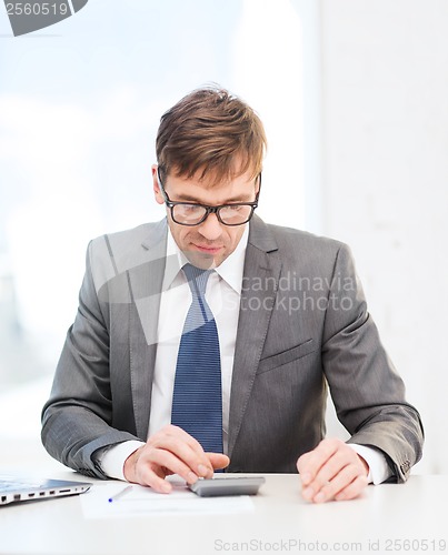 Image of businessman with papers and calculator