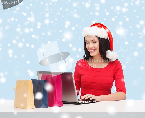 Image of woman with shopping bags and laptop computer