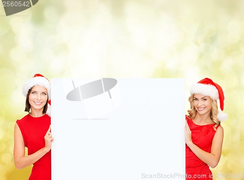 Image of women in santa helper hats with blank white board