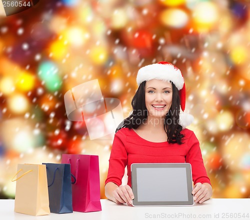 Image of smiling woman in santa helper hat with tablet pc