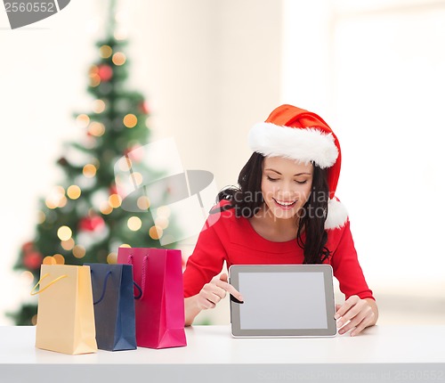 Image of smiling woman in santa helper hat with tablet pc