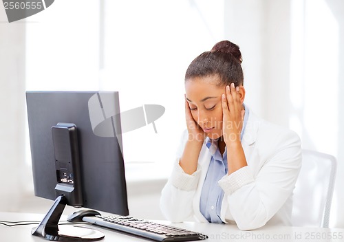 Image of stressed african woman with computer