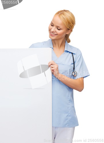 Image of smiling female doctor or nurse with blank board