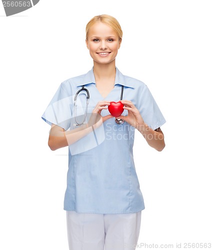 Image of smiling female doctor or nurse with heart