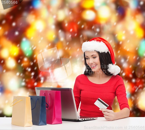 Image of woman with shopping bags, laptop and credit card