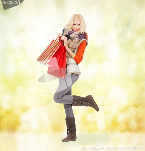 Image of teenage girl in winter clothes with shopping bags