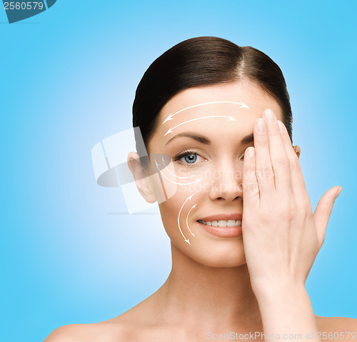 Image of smiling young woman covering face with hand