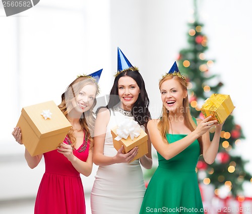 Image of three smiling women in blue hats with gift boxes