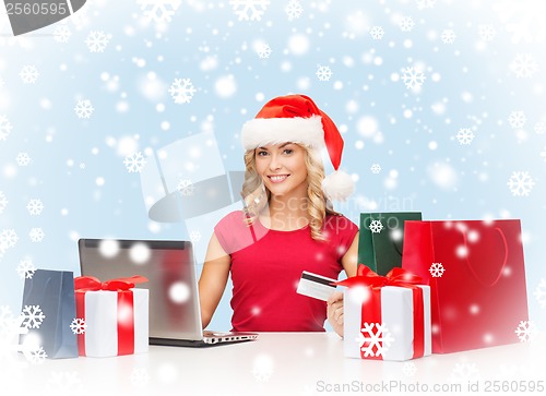 Image of woman with gifts, laptop computer and credit card