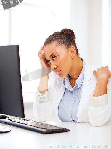 Image of stressed african woman with computer