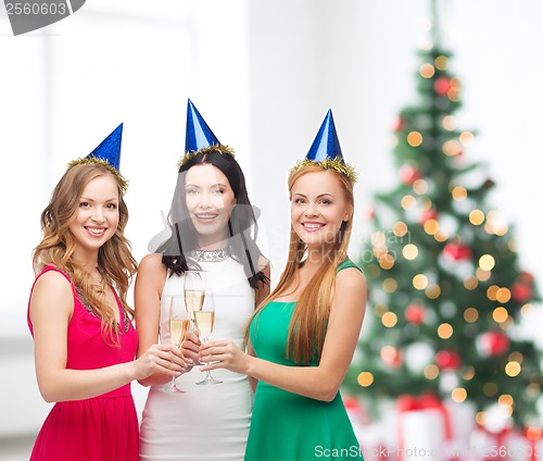 Image of three women wearing hats with champagne glasses