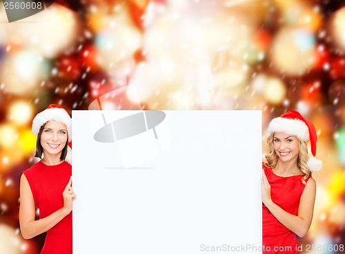 Image of women in santa helper hats with blank white board
