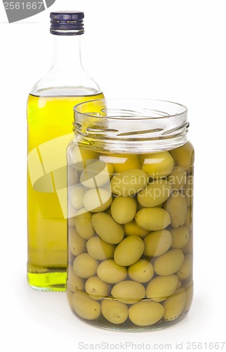 Image of Green olives preserved in bank and a bottle of olive oil